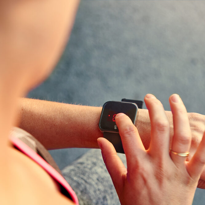 Woman,Programming,Her,Smartwatch,Before,Going,Jogging,To,Track,Performance